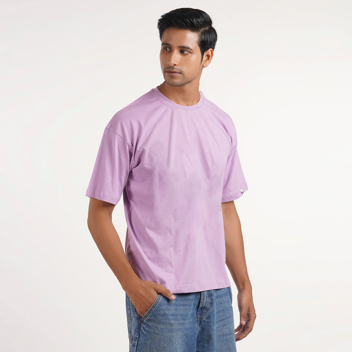 Buy men's plain oversized T-shirt in lavender with drop shoulder and graphic print, made from 100% cotton for comfort.
