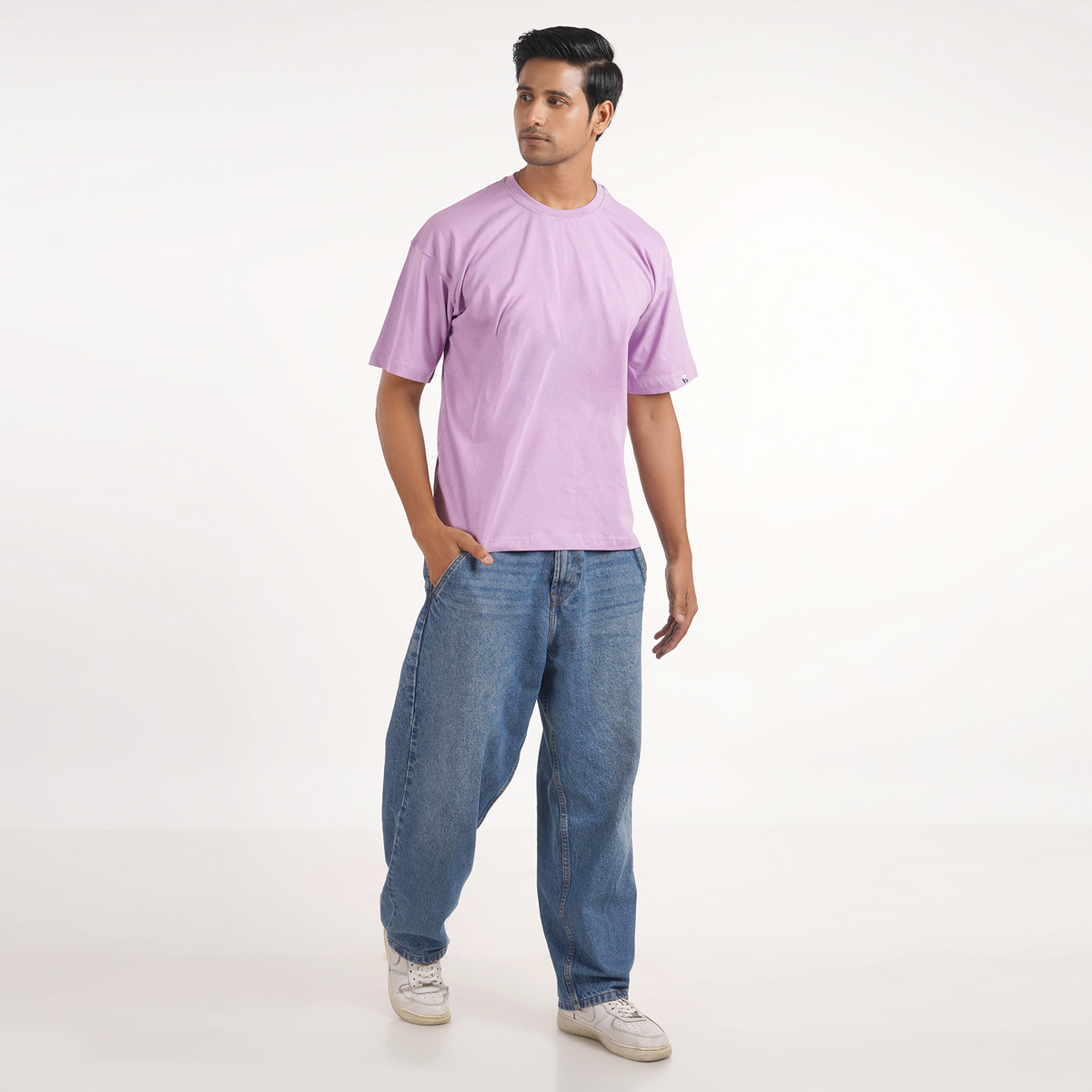 Lavender oversized T-shirt for men, featuring drop shoulders, graphic print, and 100% cotton fabric for a stylish look.
