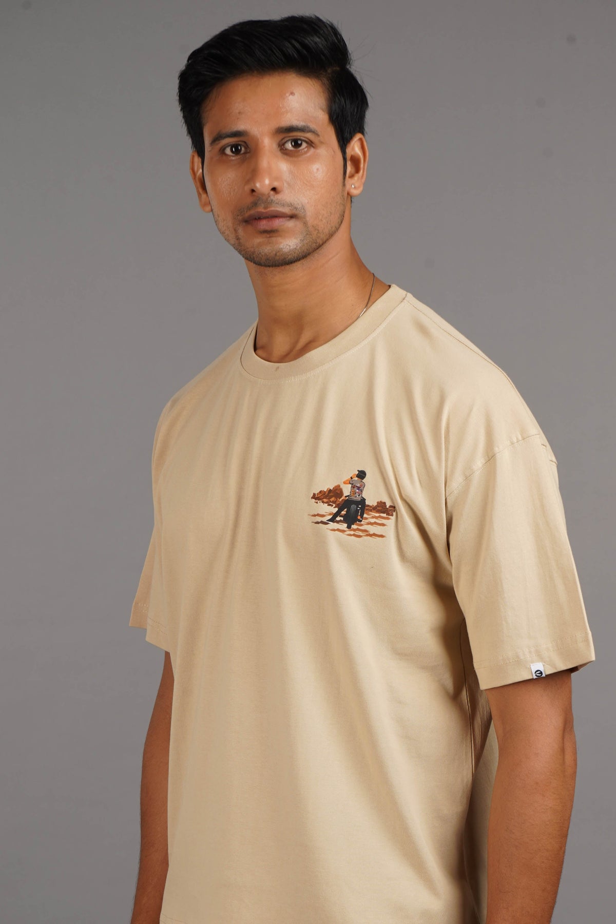 Shop the Biker Oversized T-Shirt in beige, offering a relaxed fit for men and women. Perfect for a laid-back, stylish vibe.
