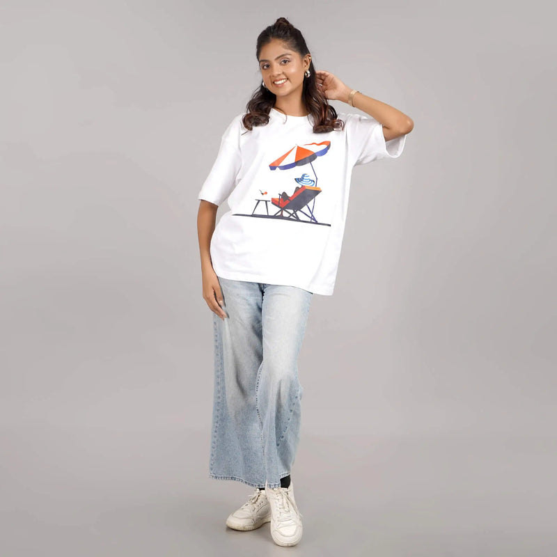 Women’s white oversized T-shirt with 'Sun Beach' graphic, round neck, and drop shoulder style. Made of cotton. Available online.