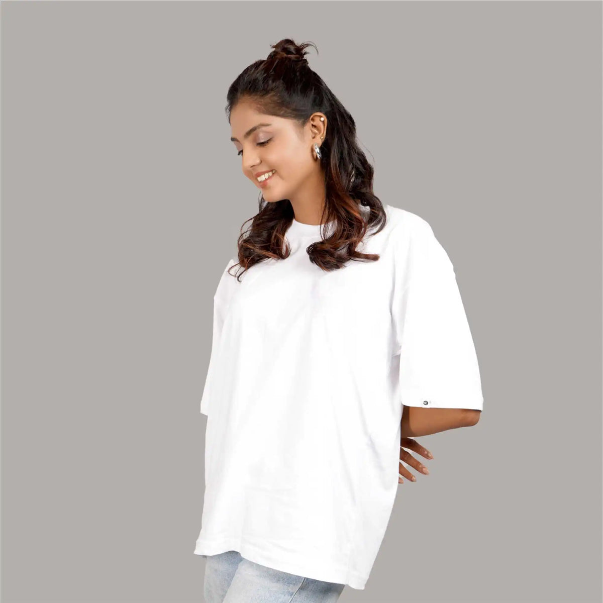 Women’s plain white oversized T-shirt with drop shoulders and a round collar. Made from soft cotton for a relaxed fit. Shop online for this versatile graphic tee